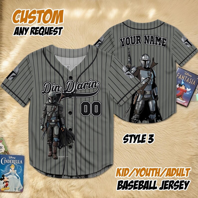 May include: Grey baseball jersey with black pinstripes, featuring a Mandalorian graphic and the name "Din Djarin" with the number "00". The jersey has the text "CUSTOM ANY REQUEST" and "KID/YOUTH/ADULT BASEBALL JERSEY".