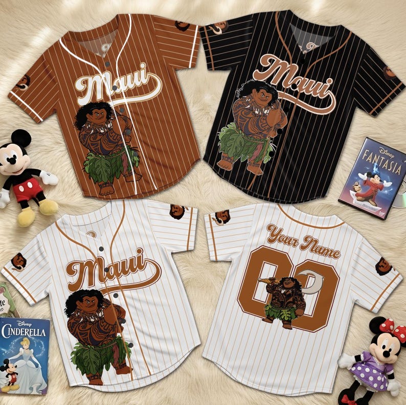 K&ouml;nnte beinhalten: Vier Baseball-Trikots mit dem Wort "Maui" und einer Cartoon-Figur. Zwei sind braun mit wei&szlig;en Nadelstreifen, eines ist schwarz mit wei&szlig;en Nadelstreifen und eines ist wei&szlig; mit braunen Nadelstreifen. Auf dem R&uuml;cken eines Trikots steht "Your Name" und eine Nummer.
