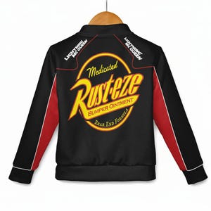 May include: Black zip-up jacket with red and white accents. The back features a large yellow and red "Rust-eze" logo with the text "Medicated Bumper Ointment" and "Rear End Formula". The sleeves have red stripes.