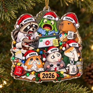 May include: A clear acrylic Christmas ornament featuring six cartoon animals in Santa hats working at a desk. Text includes names Michael, Jack, Sarah, Emma, David, Lily, and phrases like 'Excel has stopped working', 'Same sheet different disaster', 'Ctrl+Z please', 'It was fine yesterday', and '2026'.