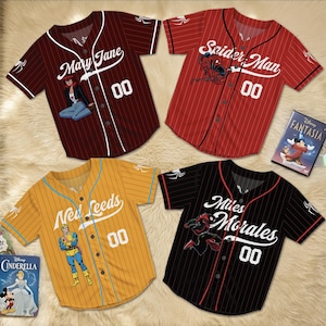 May include: Four baseball jerseys with comic book themes. The jerseys are maroon, red, yellow, and black with white lettering and the number "00". The maroon jersey says "Mary Jane", the red jersey says "Spider Man", the yellow jersey says "New Leeds", and the black jersey says "Miles Morales".