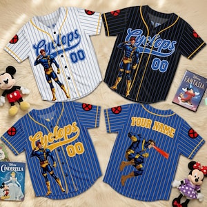 May include: Four baseball jerseys with the Cyclops character design. The jerseys are white, black, and blue with vertical stripes and the word "Cyclops" in script. Each jersey has the number "00" and a character illustration. One jersey has "Your Name" on the back.