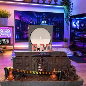 May include: A detailed Raccoon Police Department (R.P.D.) themed display piece. The display features a miniature brick building with a barred gate, caution tape, and traffic cones. The R.P.D. logo is prominently displayed above the building.