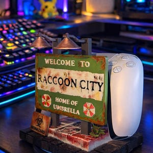 Pode incluir: Uma caneca de cerâmica branca com uma alça preta e o texto "But First, Coffee" em estilo manuscrito. A caneca está sobre uma superfície branca. Ideal para bebidas quentes.