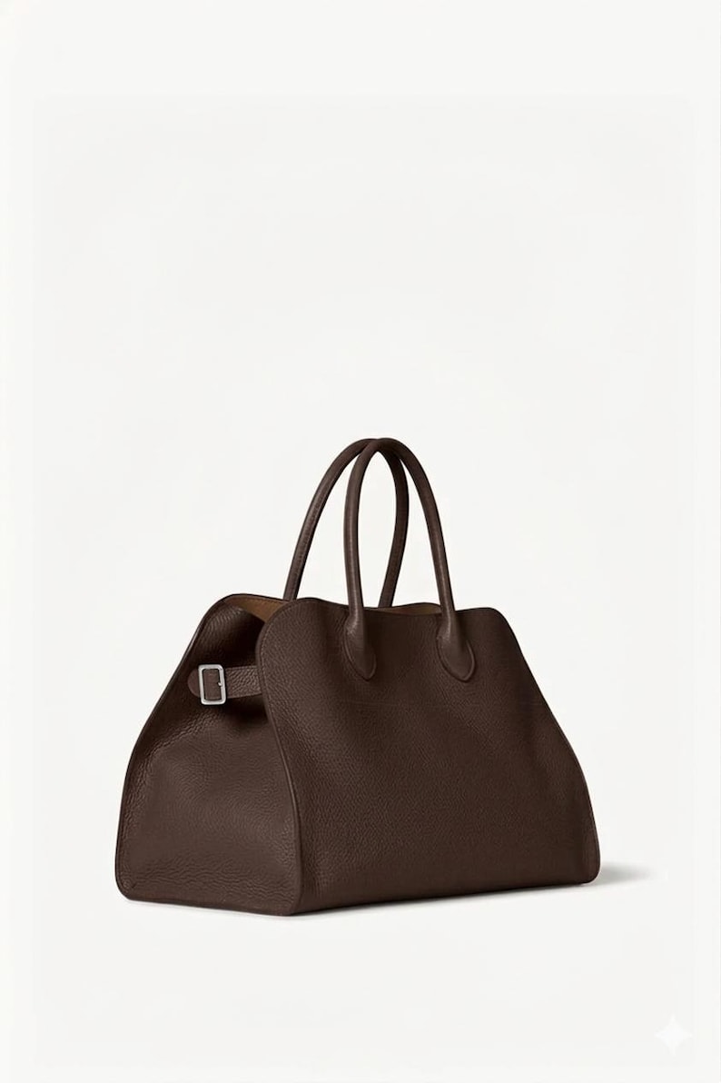Peut inclure: Un sac &agrave; main en cuir marron avec deux poign&eacute;es sup&eacute;rieures et une forme rectangulaire. Le sac a une fermeture &agrave; boucle sur le c&ocirc;t&eacute; et une surface textur&eacute;e. L'int&eacute;rieur est de couleur marron clair.