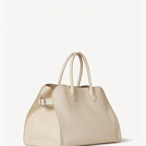 Peut inclure: Sac &agrave; main en cuir cr&egrave;me avec deux poign&eacute;es sup&eacute;rieures et une forme rectangulaire. Le sac est dot&eacute; d'une fermeture &agrave; boucle sur le c&ocirc;t&eacute; et d'un design structur&eacute;. Sa couleur neutre et son style classique en font un accessoire polyvalent.