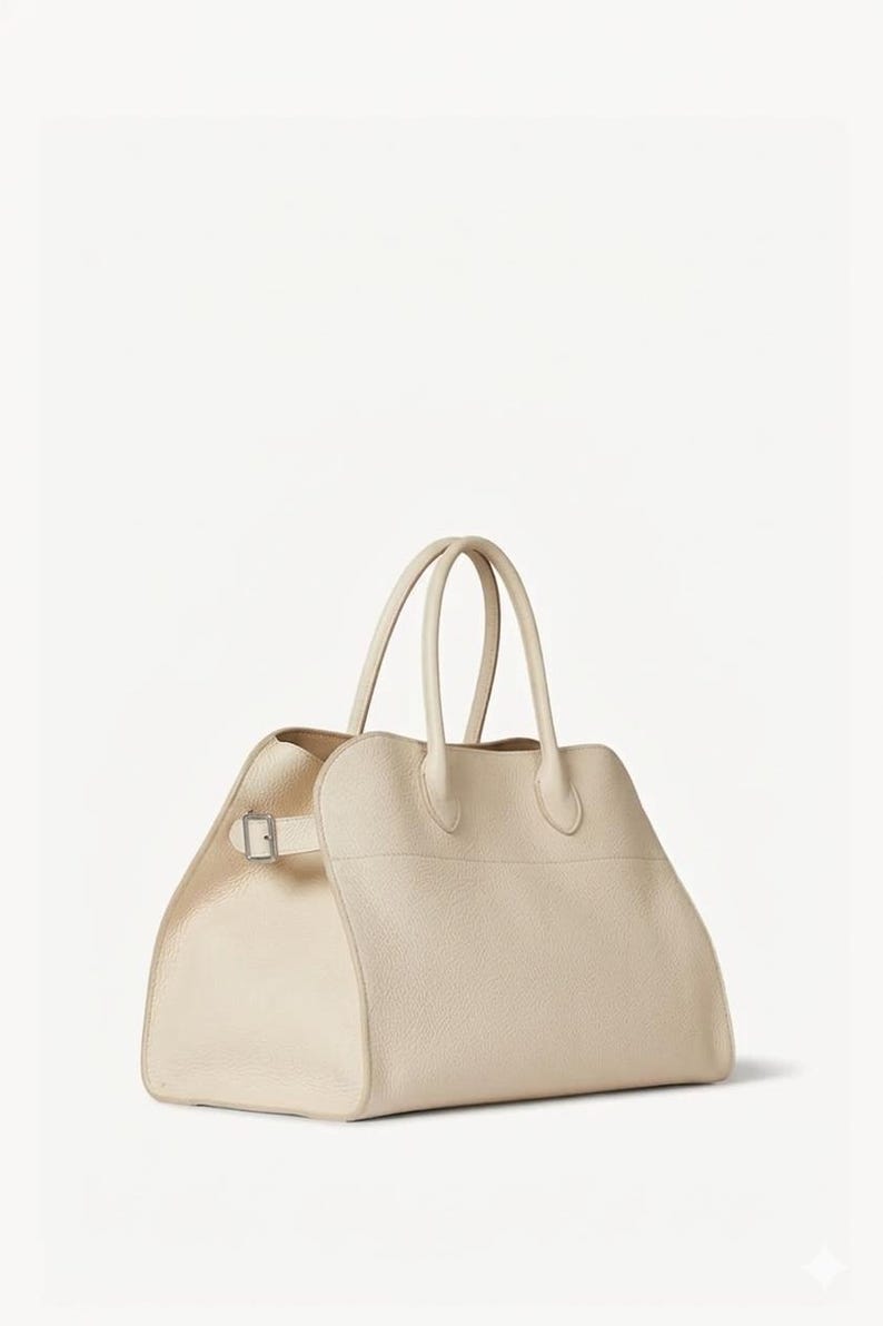 Peut inclure: Sac &agrave; main en cuir cr&egrave;me avec deux poign&eacute;es sup&eacute;rieures et une forme rectangulaire. Le sac est dot&eacute; d'une fermeture &agrave; boucle sur le c&ocirc;t&eacute; et d'un design structur&eacute;. Sa couleur neutre et son style classique en font un accessoire polyvalent.