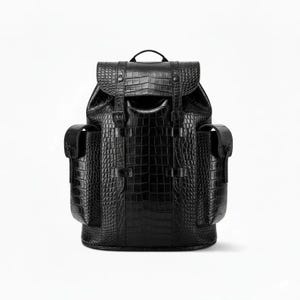 May include: A black backpack with a crocodile skin texture. The backpack has a flap closure with two buckle straps and two side pockets. It has a top handle and adjustable shoulder straps.