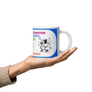 May include: White ceramic mug with a blue border and a cartoon computer character dancing with musical notes. The mug has the words "AUTOMATION, INTELLIGENCE, MUSIC, PUBLISHING" in various colors.
