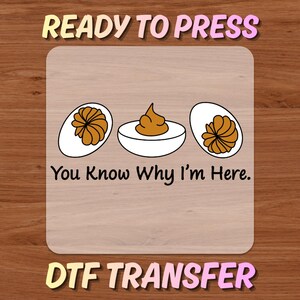 May include: DTF transfer design featuring a graphic of deviled eggs. The design includes the text "READY TO PRESS", "You Know Why I'm Here", and "DTF TRANSFER". The image has a wooden background.