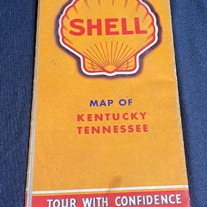 May include: Vintage Shell map of Kentucky and Tennessee. The map features a prominent Shell logo in a red and yellow seashell design. The text "Map of Kentucky Tennessee" and "Tour with Confidence" are also visible.