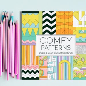 May include: A colouring book with the title "COMFY PATTERNS BOLD & EASY COLOURING BOOK". The cover features a colourful geometric pattern with a variety of shapes and colours, including yellow, orange, pink, blue, and green.