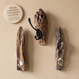 Peut inclure: Trois patères murales fabriquées à partir de morceaux de bois flotté naturel. Chaque pièce comporte un crochet en métal noir, blanc ou argenté. Un disque porte l'inscription : PIÈCES UNIQUES CHOISISSEZ LA VÔTRE ! UNIQUE PIECES CHOOSE YOURS !