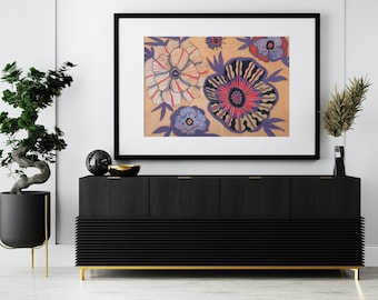 May include: A framed horizontal wall art print featuring a tan background with stylized floral illustrations in shades of red, pink, blue, and black. The artwork is displayed in a black frame with a white mat, hanging above a black sideboard.