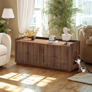 May include: A wooden cat house with a dark brown finish, featuring vertical slat detailing on the front doors. The top surface holds decorative items. A cat is entering the house through a side opening. The house is on a hardwood floor.