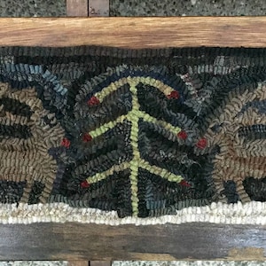 May include: A hand-hooked rug with a dark green background featuring a stylized green tree with red berries and two brown deer on either side. The rug has a white border and the text "Mavis Butterfield" is visible at the bottom.