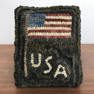 May include: A green and white hooked rug with an American flag and the word "USA" in white letters.