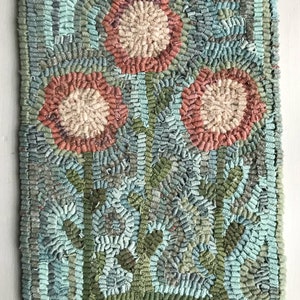May include: A hand-stitched rug with a floral design. The rug features three flowers with red and beige centers and green stems. The background is a mix of blue, green, and gray colors. The rug is signed "Mavis Butterfield".