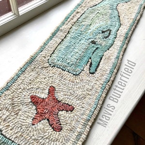 May include: A hand-stitched rug featuring a blue whale design, a red starfish, and the text "Mavis Butterfield".