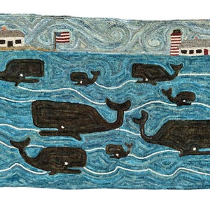 May include: A blue and white rug with a whimsical design of whales swimming in the ocean. The rug features a lighthouse and a house on a small island in the background.
