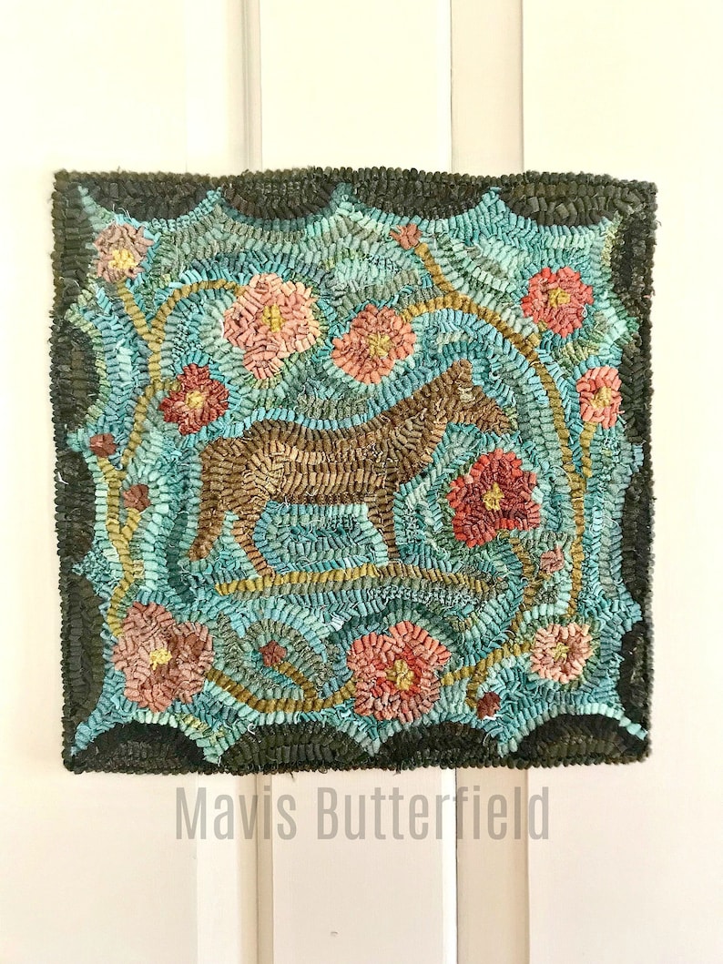 May include: A hand-hooked rug with a brown horse design surrounded by teal blue and pink flowers. The rug has a dark green border and the artist's signature "Mavis Butterfield" is written below the rug.