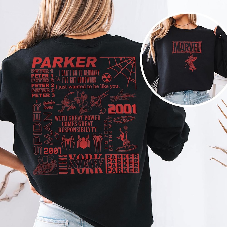 May include: Black sweatshirt with red graphic text and illustrations. The text includes "PARKER", "SPIDER-MAN", and quotes. Illustrations of a spider web, spider, and other comic book elements are also present. The Marvel logo is on the right side.
