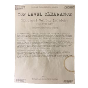 May include: A vintage document from the Central Intelligence Agency, marked "TOP SECRET," detailing a "Monument Valley Incident." The document is titled "TOP LEVEL CLEARANCE." The text is printed in black ink on aged, cream-coloured paper with a coffee stain. The document's theme is classified information.