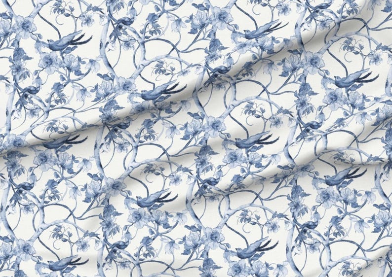 Peut inclure: Un tissu avec un motif r&eacute;p&eacute;titif d'oiseaux bleus, de fleurs et de branches sur fond blanc. Le motif a un effet aquarelle, avec des ombres douces et des d&eacute;tails d&eacute;licats. Les oiseaux sont en vol et les fleurs sont en fleurs.