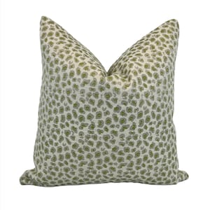 May include: A green and white leopard print throw pillow. The pillow is made of a soft, textured fabric.