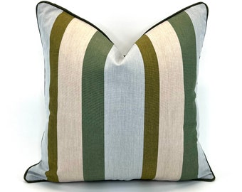May include: A square decorative pillow with vertical stripes in olive green, light green, beige, and light blue. The pillow has a dark green trim and is set against a white background.