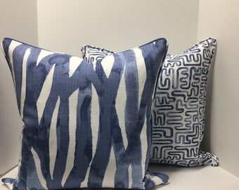 Peut inclure: Deux coussins décoratifs avec des motifs bleus et blancs. Un coussin a un motif abstrait bleu et blanc, et l'autre a un motif géométrique bleu et blanc.