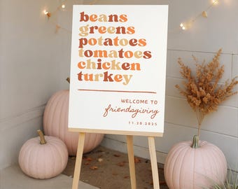 May include: A white Friendsgiving sign on a wooden easel, listing menu items in shades of orange and brown. Pink pumpkins and decorative lights surround the sign. The sign reads "Welcome to Friendsgiving 11.20.2025".