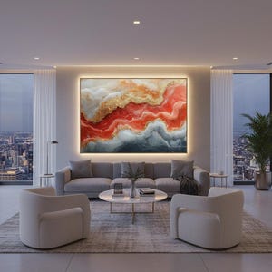 以下が含まれることがあります： 都市の景色を望む大きな窓のあるモダンなリビングルーム。グレーのソファ、2つの白いアームチェア、丸いコーヒーテーブルがあります。赤、金、グレーの色調の大きな抽象画がソファの上に飾られています。