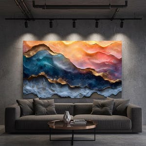 Puede incluir: Gran obra de arte mural abstracto con un paisaje montañoso en tonos naranja, azul y dorado. La obra de arte cuelga sobre un sofá gris con cojines a juego. La habitación tiene un diseño moderno e industrial con una pared de hormigón.