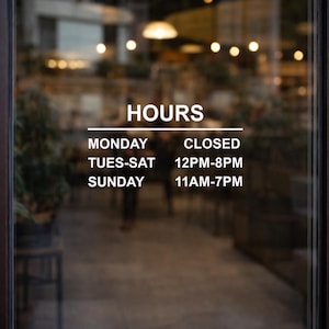 May include: A glass door with the word "HOURS" in white lettering. Below, the operating hours are listed: Closed on Monday, 12 PM-8 PM Tuesday to Saturday, and 11 AM-7 PM on Sunday. A gold handle is on the right side.