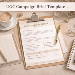 Könnte beinhalten: Eine Draufsicht mit einem Klemmbrett mit einem Dokument "UGC Campaign Brief Template", einer Kaffeetasse, einem Notizbuch, einem Stift, einem Smartphone und einem Laptop. Die Gegenstände sind auf einer neutralen Oberfläche angeordnet.
