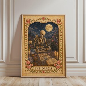 Könnte beinhalten: Gerahmter Kunstdruck mit einem Skelett, das Tarotkarten unter einem Vollmond liest. Das Kunstwerk hat eine Vintage-Ästhetik mit einem floralen Rahmen und dem Text "THE ORACLE". Die Farbpalette umfasst Beige, Rosa und Blau.