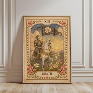 Könnte beinhalten: Gerahmter Tarotkarten-Druck mit der Karte Tod. Das Bild zeigt eine skelettartige Figur in Rüstung, die ein weißes Pferd reitet und eine Flagge mit einer weißen Rose hält. Die Karte ist mit floralen und Rosenakzenten umrahmt, mit dem Wort "DEATH" unten.