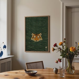 Pode incluir: Impress&atilde;o art&iacute;stica emoldurada com o rosto de um tigre emergindo de &aacute;gua verde com padr&otilde;es de ondas douradas. O tigre tem listras laranja e pretas. A obra de arte est&aacute; em uma moldura de madeira e inclui texto japon&ecirc;s.