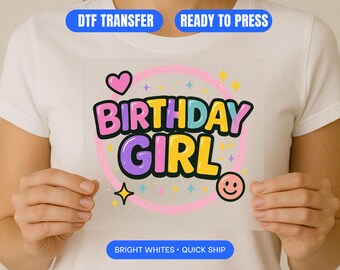 Può includere: Un trasferimento DTF colorato con le parole "BIRTHDAY GIRL" in lettere a bolle, circondato da un cerchio rosa, cuori, stelle e una faccina sorridente. Il design è pronto per essere pressato e presenta bianchi brillanti.