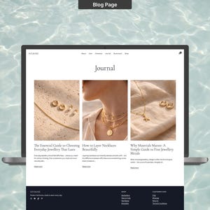 Op de afbeelding: Een laptop met een blogpagina met de titel "Journal". De pagina bevat drie artikelen over sieraden, waaronder "De essenti&euml;le gids voor het kiezen van alledaagse sieraden die lang meegaan". De achtergrond is een lichtblauwe watertextuur.