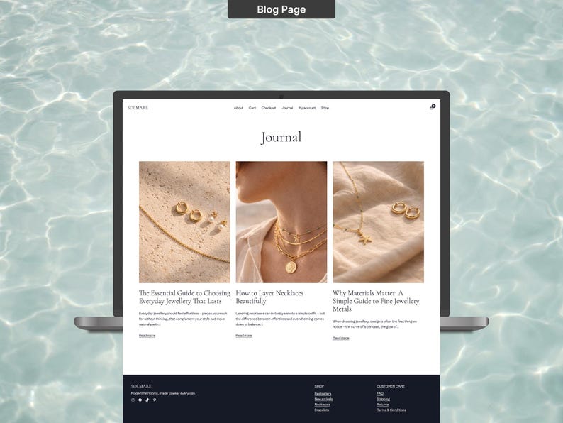 Op de afbeelding: Een laptop met een blogpagina met de titel "Journal". De pagina bevat drie artikelen over sieraden, waaronder "De essenti&euml;le gids voor het kiezen van alledaagse sieraden die lang meegaan". De achtergrond is een lichtblauwe watertextuur.
