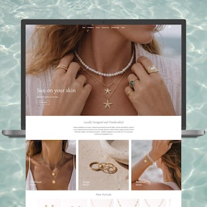 May include: A laptop displays a jewelry website with the text "Sun on your skin." The website features necklaces, rings, and bracelets. The model in the image is wearing a pearl necklace, gold necklaces, and rings. The background is a water surface.