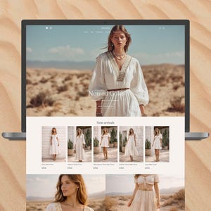 May include: A laptop displays a fashion website with a desert backdrop. The website features a woman in a white dress, the text "Nomad Gold," and images of white dresses. The laptop sits on a sandy surface.