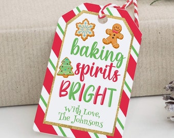 May include: A red and green striped gift tag with a gold glitter border. The tag features a gingerbread man, a snowflake, and a Christmas tree. The text on the tag reads "baking spirits bright" and "With Love, The Johnsons".