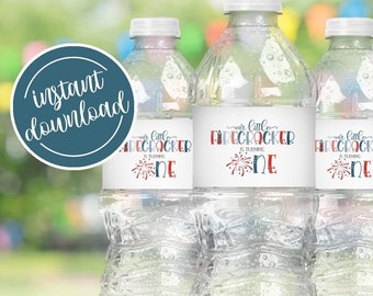 Puede incluir: Tres botellas de agua de plástico transparente con etiquetas que dicen "Nuestro pequeño petardo cumple un año" con un gráfico de fuegos artificiales rojo, blanco y azul. Las etiquetas están impresas en papel blanco.