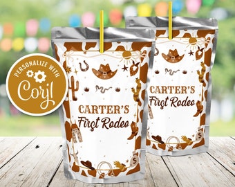 Può includere: Una scatola di succo argentata con un'etichetta bianca a tema cowboy. L'etichetta ha uno sfondo a stampa di mucca marrone e bianco con illustrazioni di cactus, serpenti, ferri di cavallo e cappelli da cowboy. Il testo sull'etichetta recita "Carter's First Rodeo".