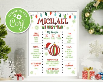 Puede incluir: Un póster imprimible de temática navideña para el primer cumpleaños de un niño. El póster presenta un adorno rojo y blanco con el número "1" en él, un gorro de Papá Noel y el nombre "MICHAEL". El póster también incluye información sobre el primer año del niño, como su peso, altura y primeras palabras.