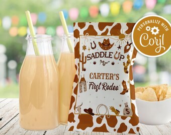 Può includere: Un sacchetto di patatine fritte con stampa di mucca marrone e bianca con un'etichetta personalizzata che dice "Saddle Up Carter's First Rodeo" e "Personalizza con Coryl".