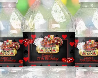 May include: Three clear plastic water bottles with labels featuring a casino theme. The labels have a black background with red accents, dice, and playing cards. The text on the label reads "Casey's 75th Birthday". A red circle with the word "Corjl" is in the upper left.